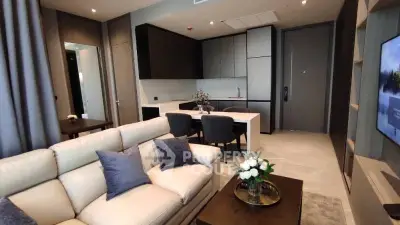 Modern living room with open kitchen, elegant decor, and cozy seating area in a stylish apartment.