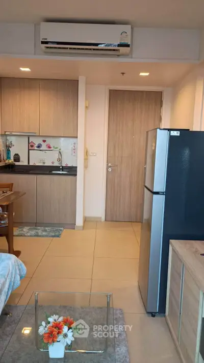 Modern apartment interior with kitchen and living area, featuring sleek appliances and stylish decor.