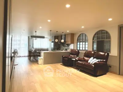 Spacious open-plan living room with modern kitchen and elegant lighting