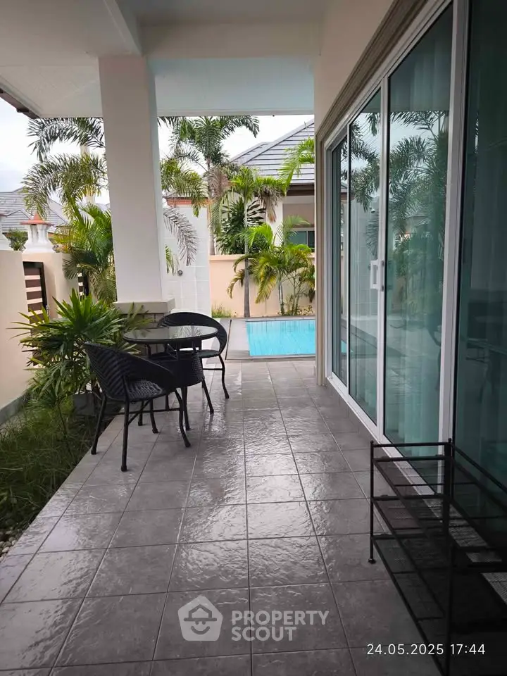 Charming patio with pool view, perfect for outdoor relaxation and entertainment.