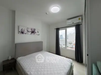 Modern bedroom with city view, featuring a comfortable bed and stylish decor.