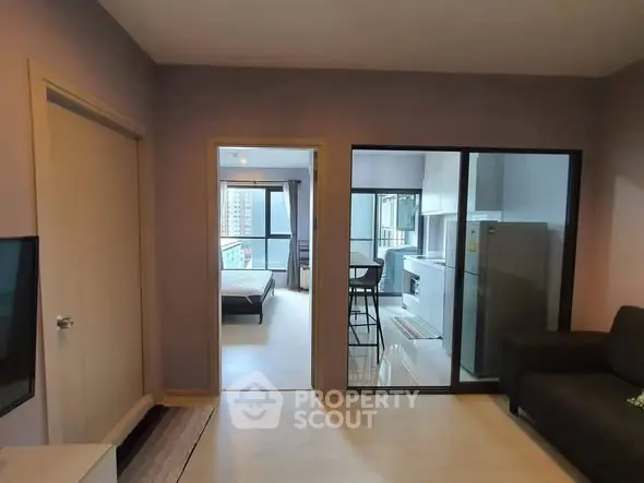 Modern apartment interior with open layout, featuring a living room, kitchen, and bedroom with large windows.