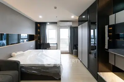 Modern bedroom with sleek design, large windows, and stylish furniture in a high-rise apartment.
