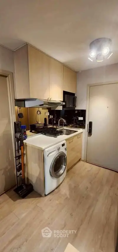 Modern kitchen with washing machine and gas stove in compact layout
