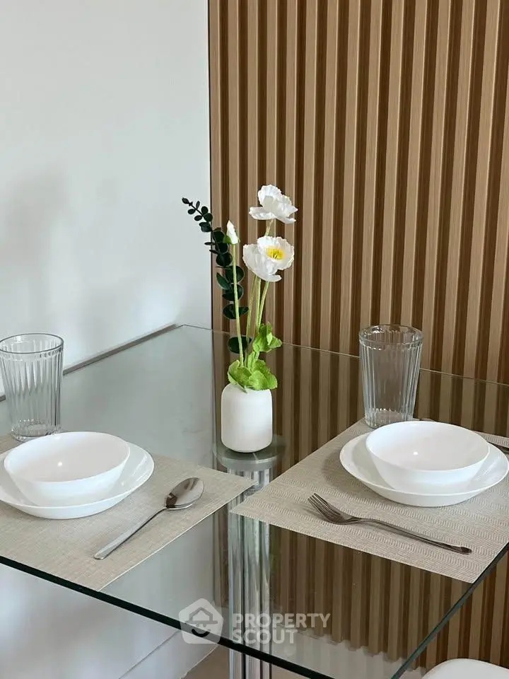 Elegant dining setup with glass table and modern decor in a stylish interior space.