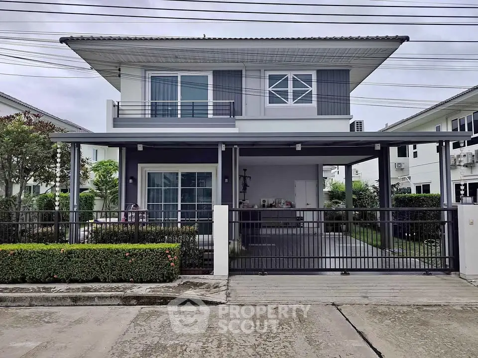 Modern two-story house with sleek design and spacious driveway in a suburban neighborhood.