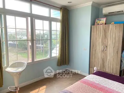 Bright bedroom with large window and modern air conditioning unit