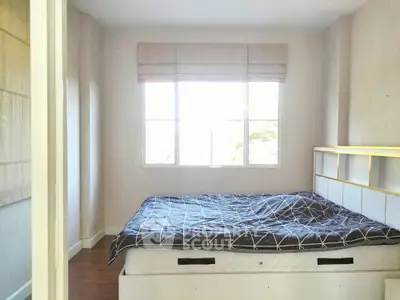 Bright bedroom with large window and modern bed frame, perfect for cozy living.