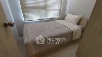 Cozy bedroom with single bed and window blinds in modern apartment