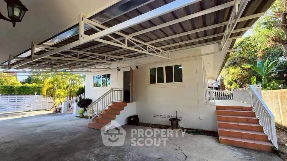 Spacious residential property with covered parking and lush greenery