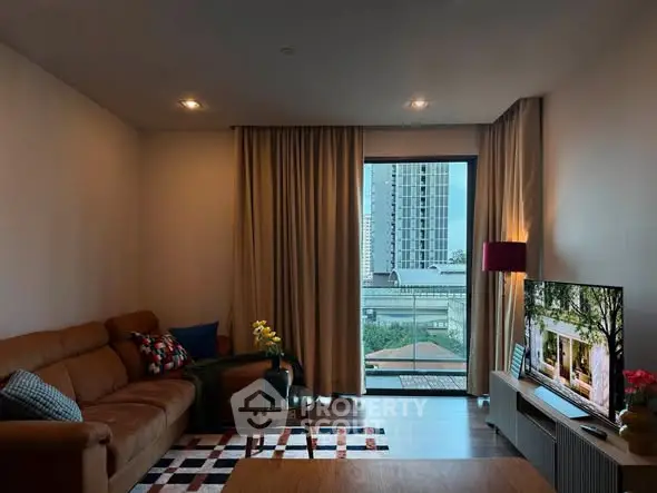 Modern living room with large window and city view, featuring stylish furniture and decor.