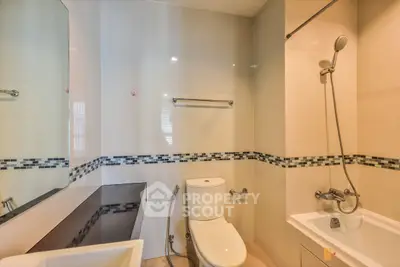 Modern bathroom with sleek design, featuring a bathtub and stylish tile accents.