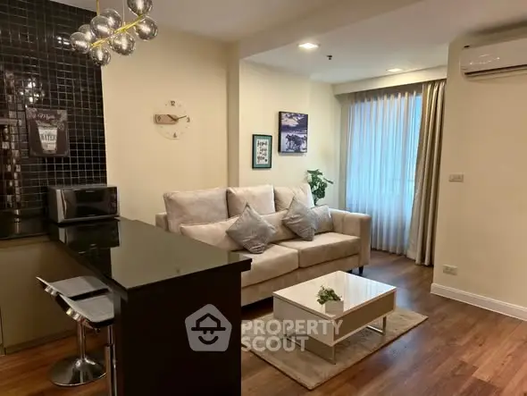 Modern living room with cozy sofa, stylish decor, and open kitchen layout in a chic apartment.