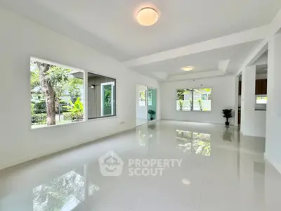 Spacious modern living room with large windows and glossy tile flooring