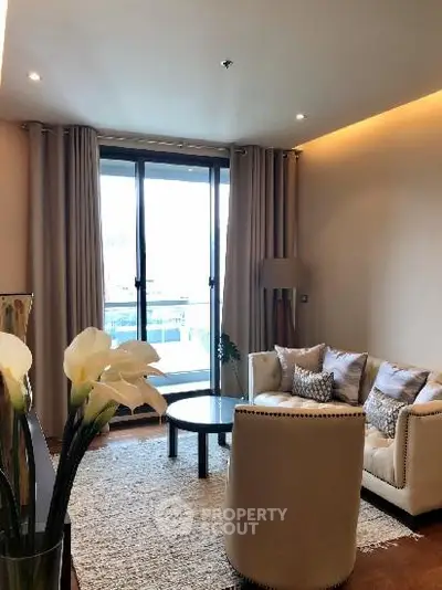 Elegant living room with cozy seating and large window view