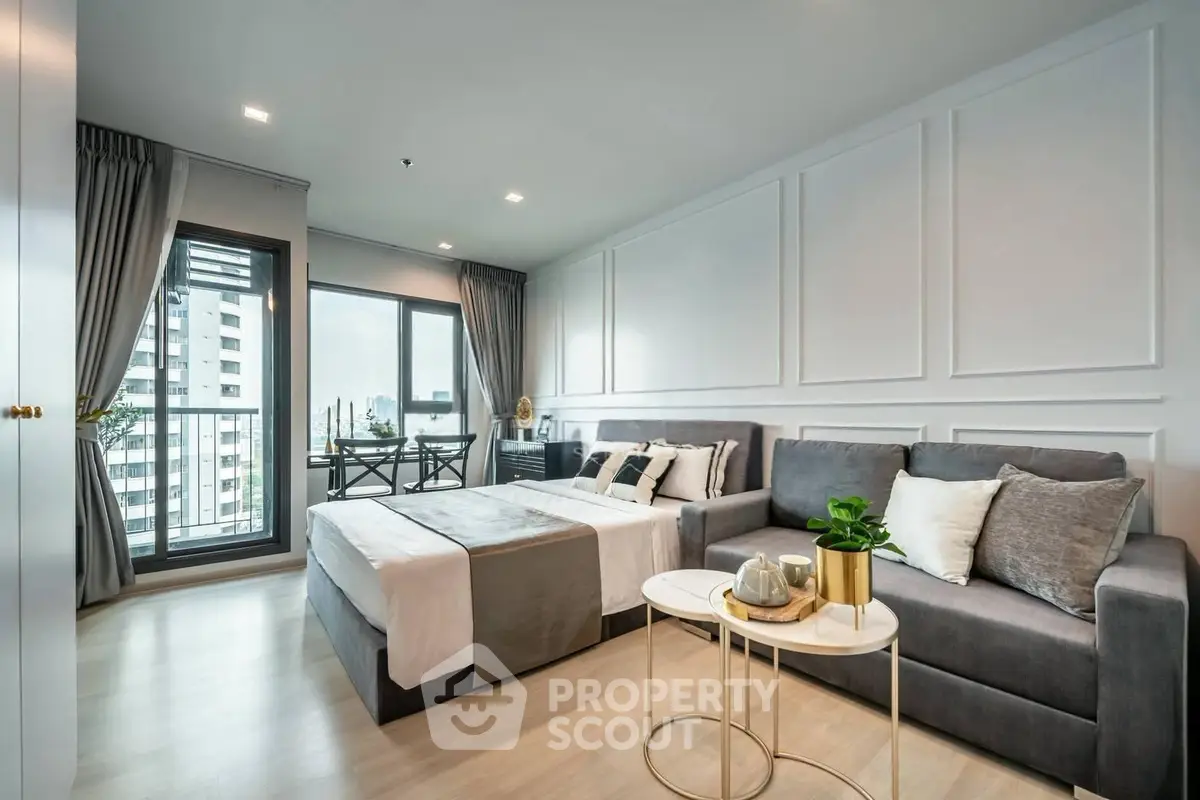Modern studio apartment with stylish decor and city view balcony.