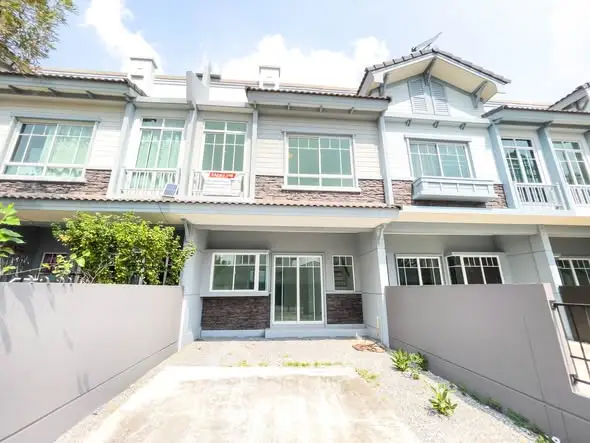 Charming townhouse exterior with modern design and spacious driveway in a serene neighborhood.