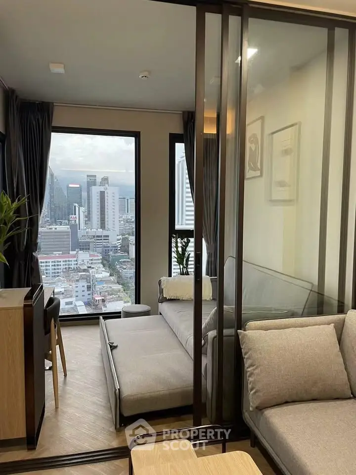 Modern living room with city view and sliding glass doors in a high-rise apartment.