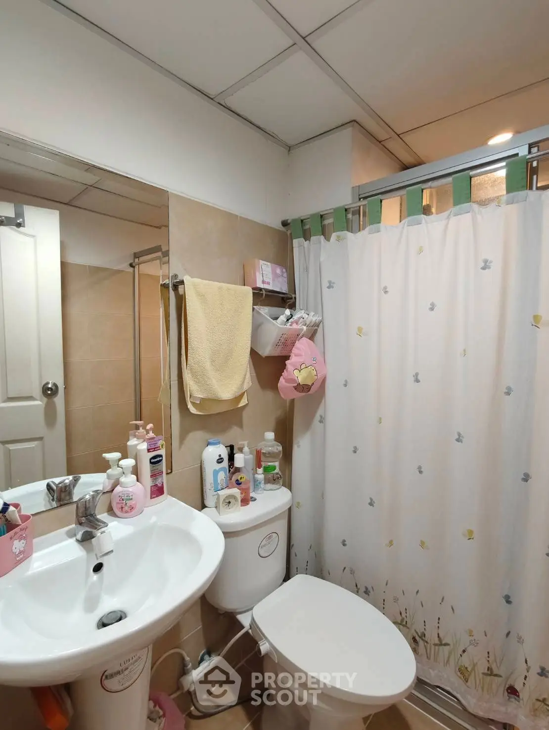 Cozy bathroom with modern fixtures and charming decor, featuring a shower curtain and ample storage space.