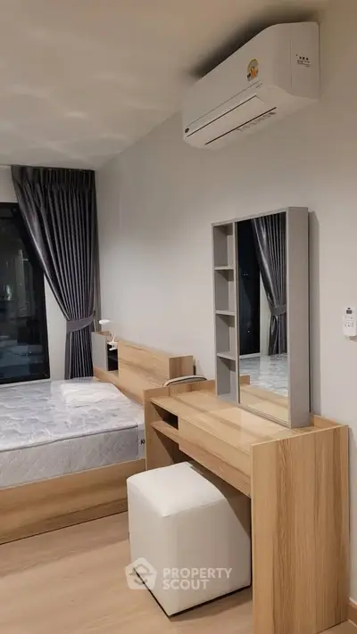 Modern bedroom with sleek wooden furniture and air conditioning unit.
