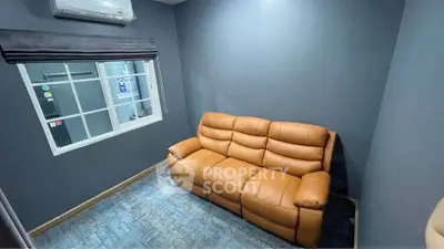 Cozy small living room with leather sofa and air conditioning