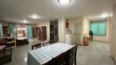 Spacious open-plan living and dining area with natural light and tiled flooring.