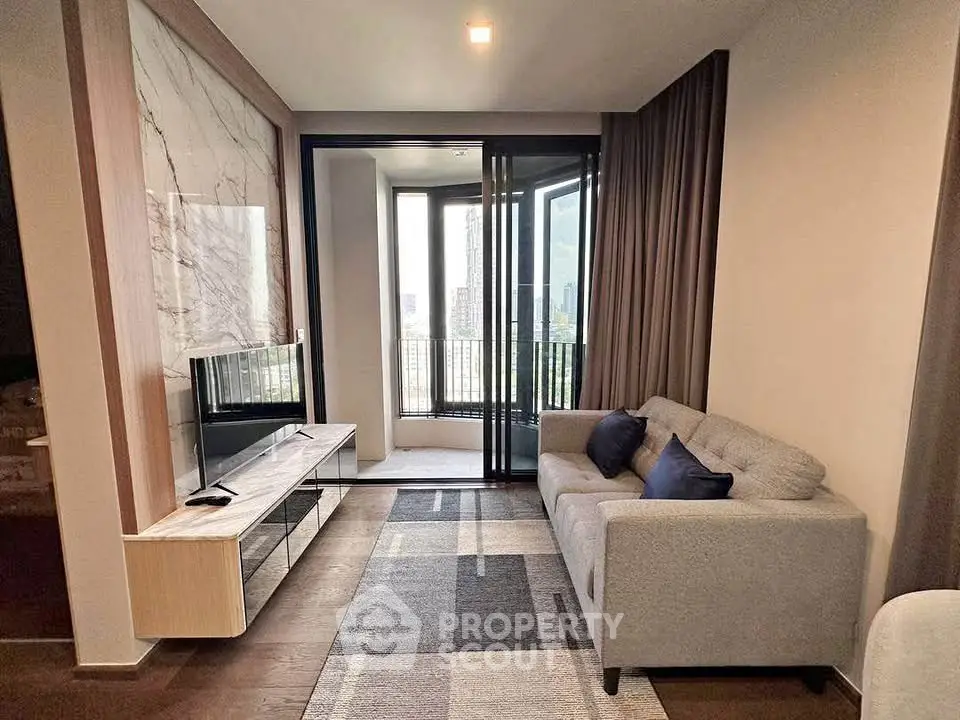 Modern living room with stylish decor and balcony view in a high-rise apartment.