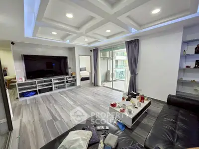 Spacious modern living room with sleek design and large TV, perfect for entertainment.