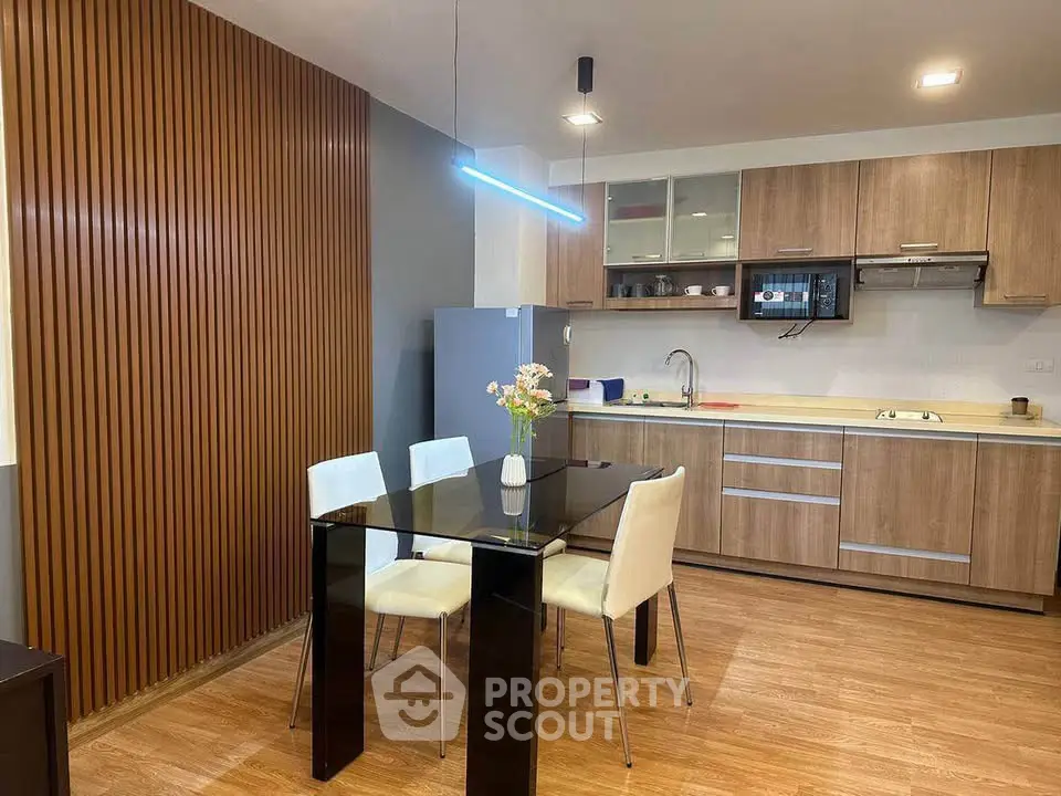 Modern kitchen with sleek dining area and stylish wooden accents