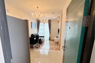 Stylish living room with chandelier and modern decor, open layout for a cozy ambiance.