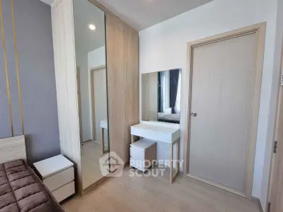 Modern bedroom with mirrored wardrobe and sleek vanity in a stylish apartment.