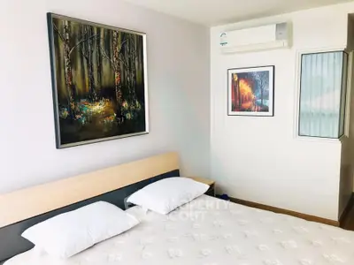 Modern bedroom with stylish artwork and air conditioning, perfect for comfort and relaxation.
