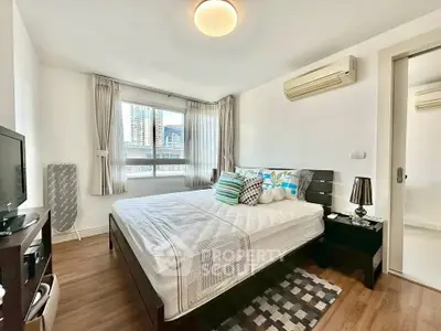 Spacious bedroom with modern decor and large window offering city views.