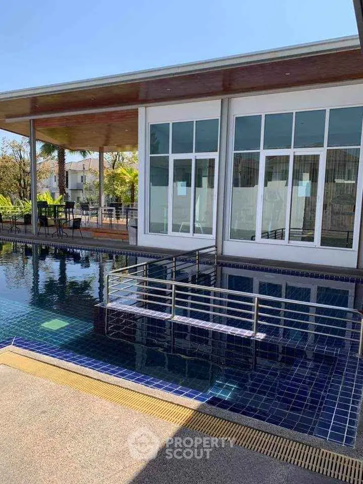 Luxurious poolside view with modern architecture and outdoor seating area.