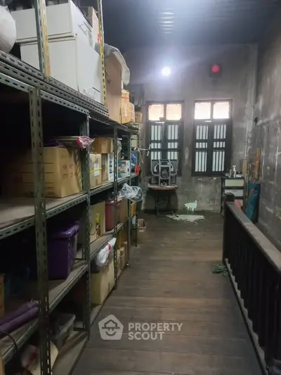 Spacious storage room with wooden flooring and ample shelving space.