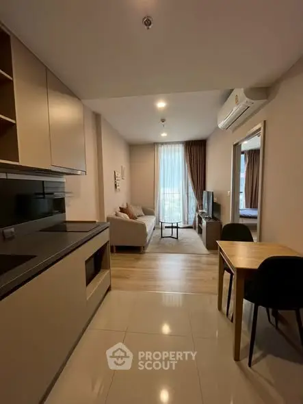Modern open-plan living room and kitchen with sleek design and natural light.