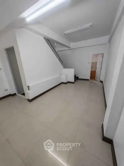 Spacious modern interior with sleek tile flooring and minimalist design, perfect for customization.