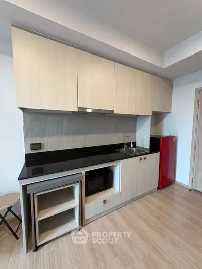 Modern kitchen with sleek cabinetry and compact appliances in a stylish apartment.