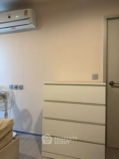 Modern bedroom with air conditioning and sleek white dresser