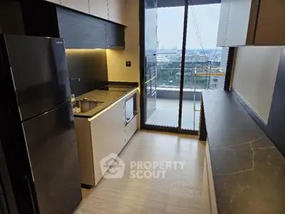 Sleek modern kitchen with high-end appliances, ample counter space, and a large window offering plenty of natural light and city views.