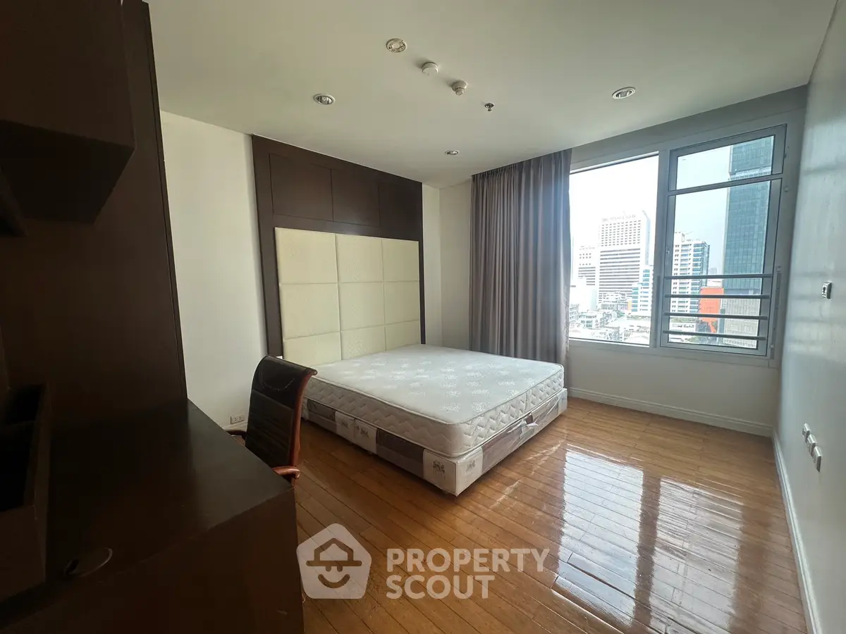 Spacious bedroom with city view and wooden flooring