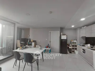 Modern open-layout kitchen and dining area with sleek furniture and ample natural light.