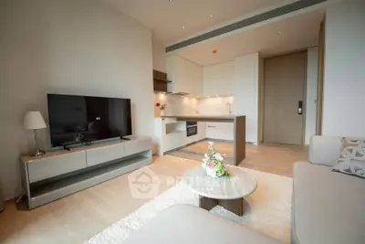 Modern living room with open kitchen, sleek furniture, and cozy decor in a stylish apartment.