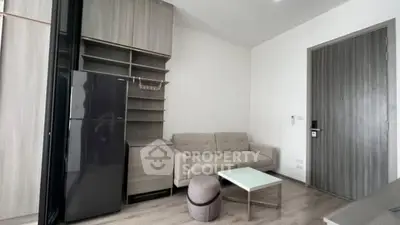 Modern living room with sleek furniture and built-in storage, featuring a stylish fridge and cozy seating area.