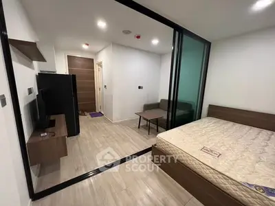 Modern studio apartment with glass partition, sleek furnishings, and cozy ambiance.