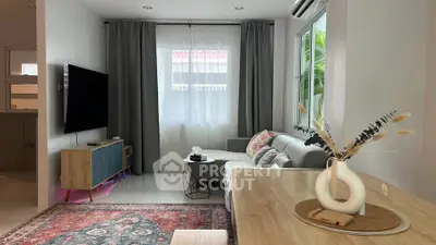 Stylish living room with modern decor and large window for natural light.