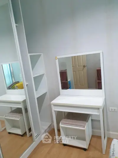 Modern bedroom with stylish white vanity and mirror, perfect for a chic and organized space.