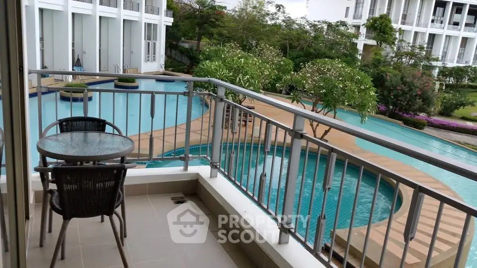 Stunning balcony view overlooking a luxurious pool in a modern residential complex.