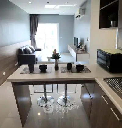 Modern open-layout kitchen and living room with sleek design and natural light.