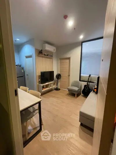 Modern living room with stylish furniture and open layout, featuring a cozy seating area and entertainment setup.